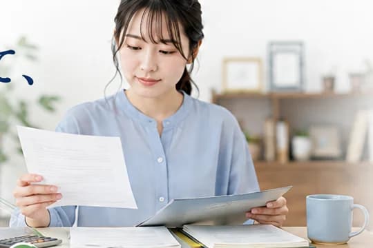 机で保険の書類を確認している女性