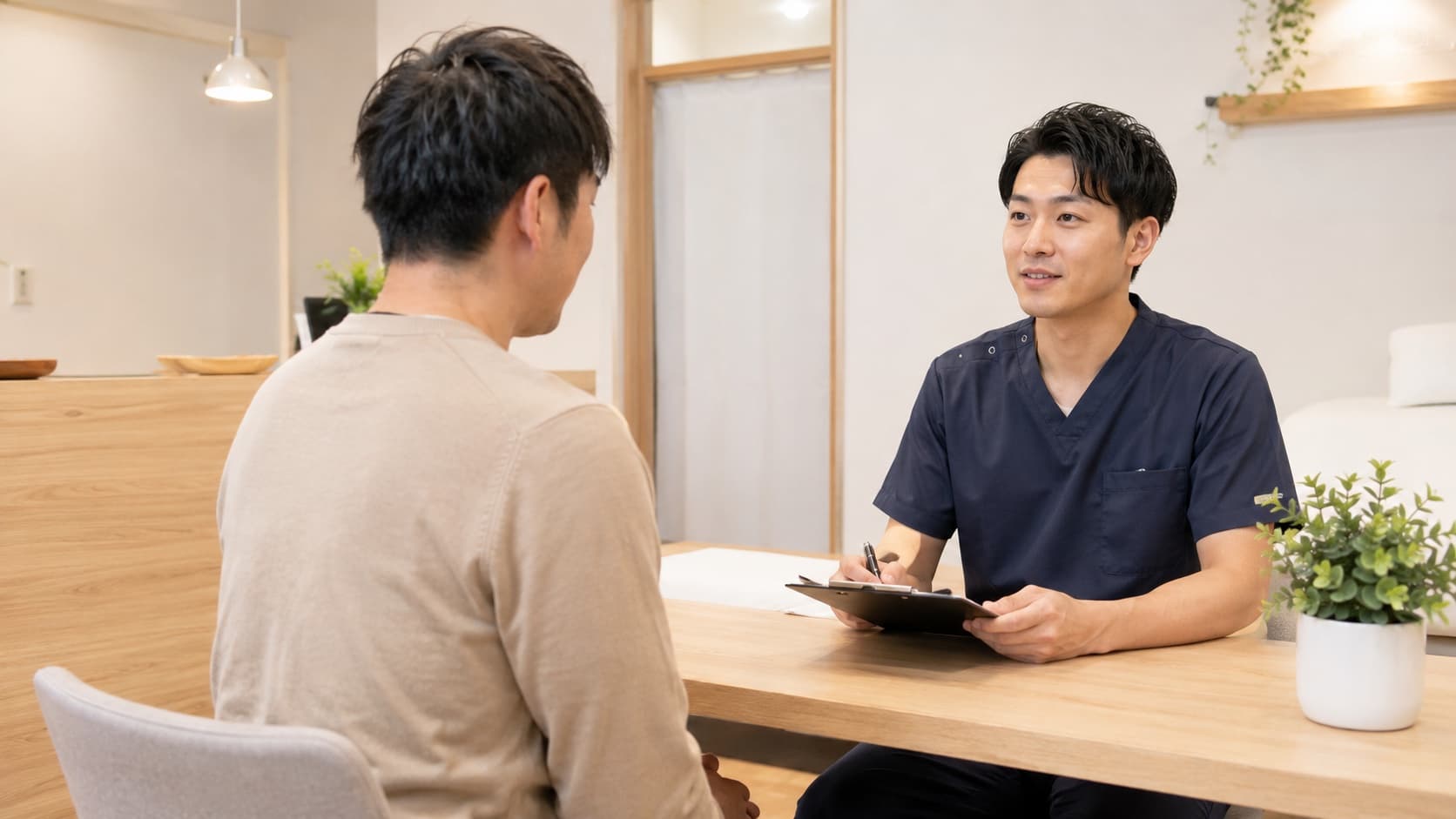 施術者が交通事故後の状況を患者から伺っている様子