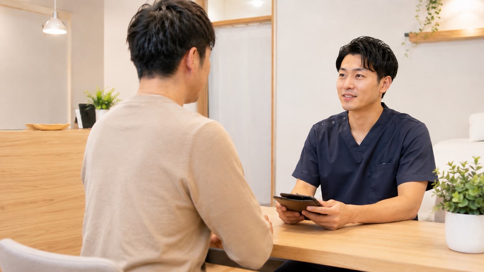 施術後にタブレットを使って今後の流れを説明している様子