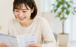 保険のパンフレットを読んでいる女性