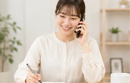 電話をしながらメモを取っている女性